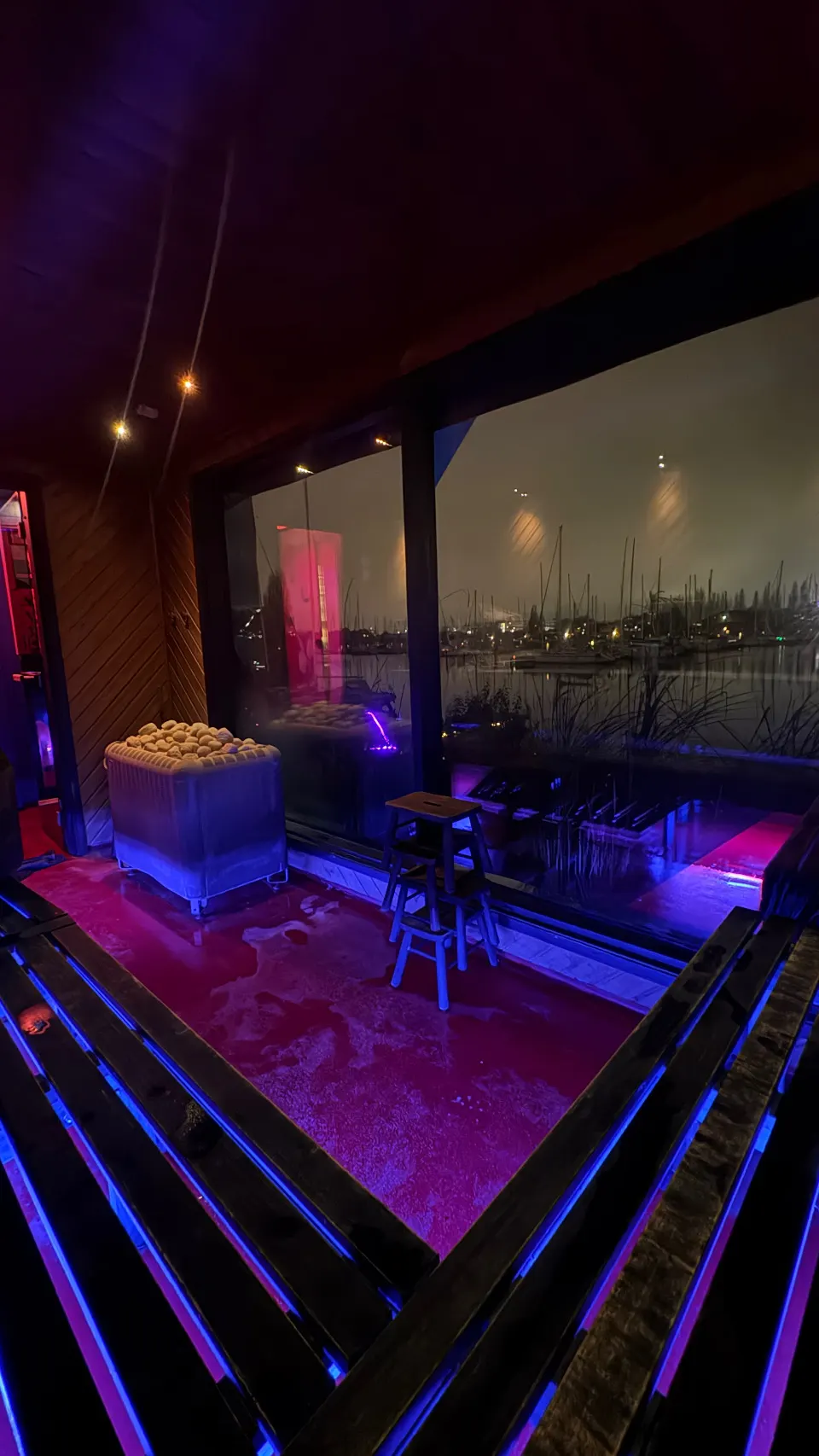 Butchers Heat om aftenen — neonlys og masteskoven gennem panoramaruden